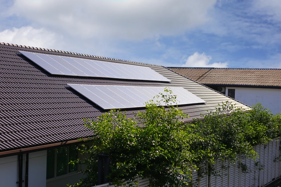 Main se tenant près d'un bouton de contrôle métallique avec éclairage LED bleu, entouré d'interfaces numériques flottantes montrant documents et écrans